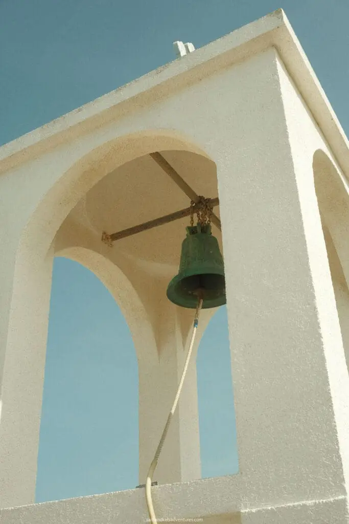 traveling to greece tips white bell tower with green bell