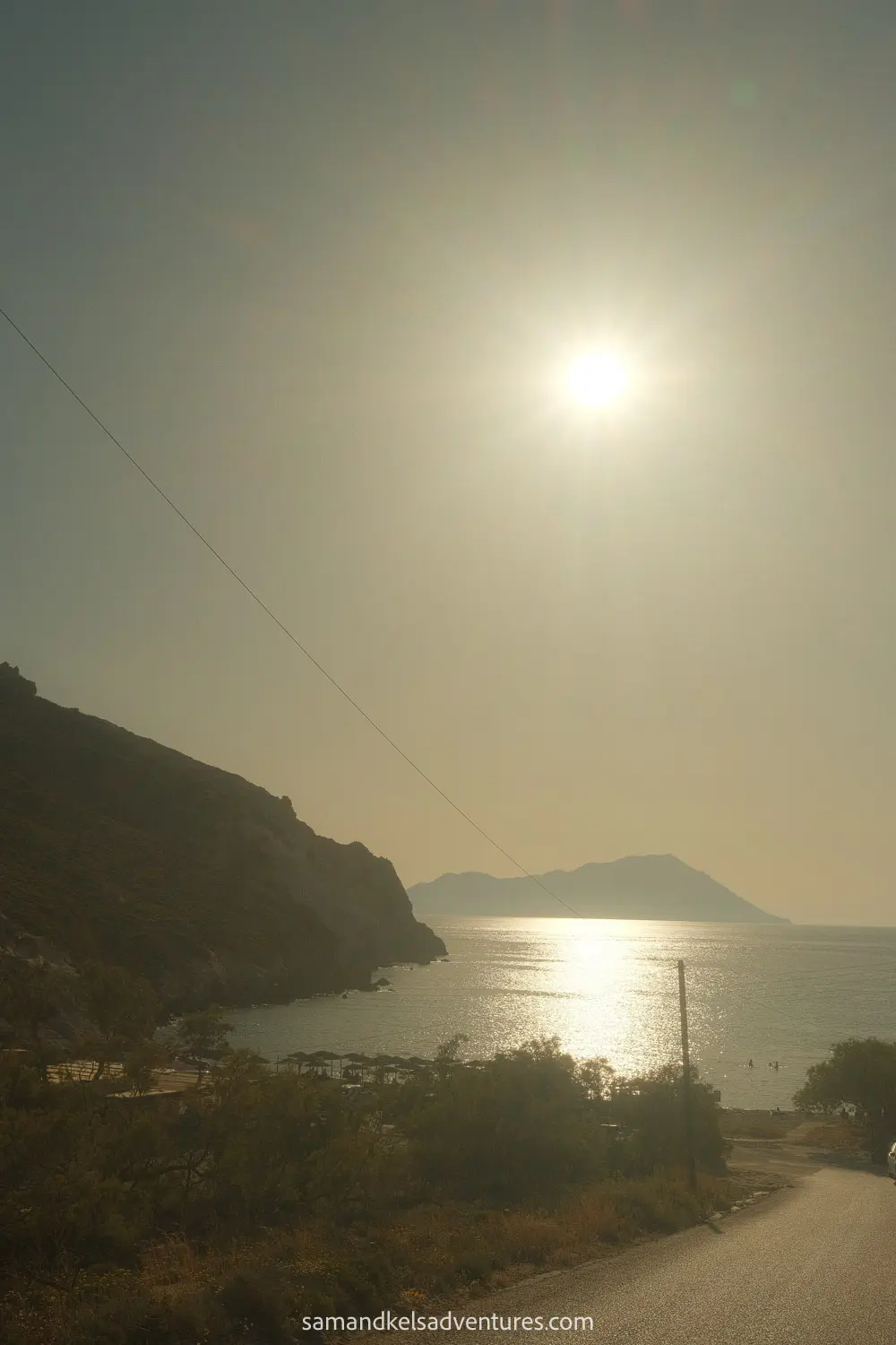 things to do in milos road to beach with mountain in the background