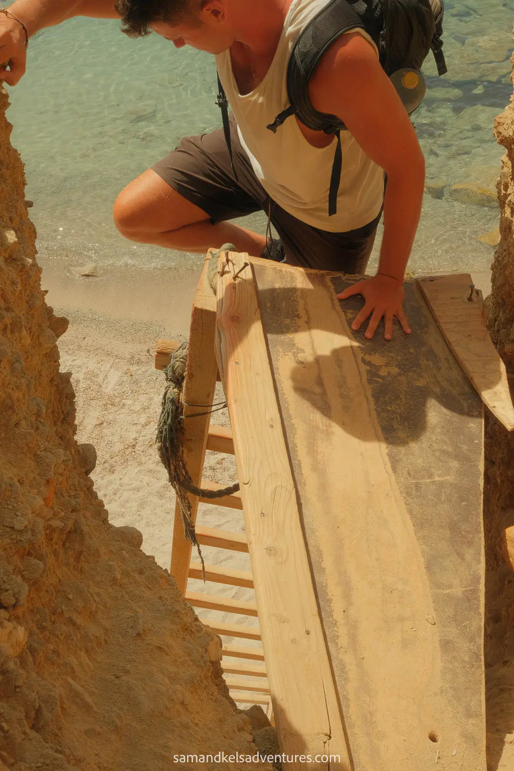 things to do in milos sam climbing down ladder to beach