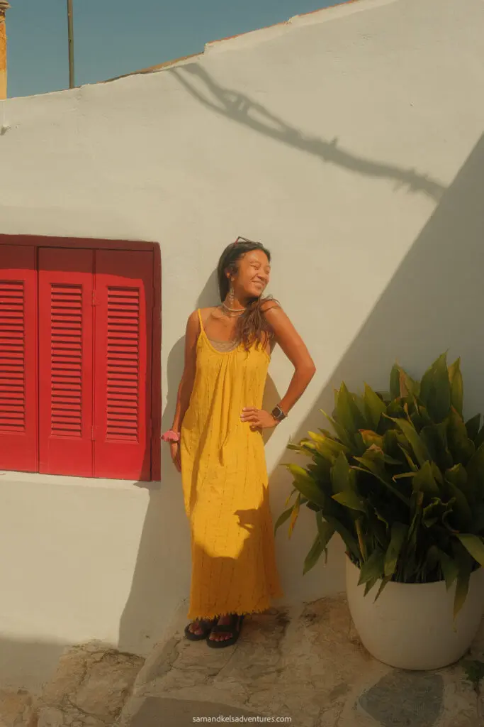 traveling to greece tips red shutters and yellow dress