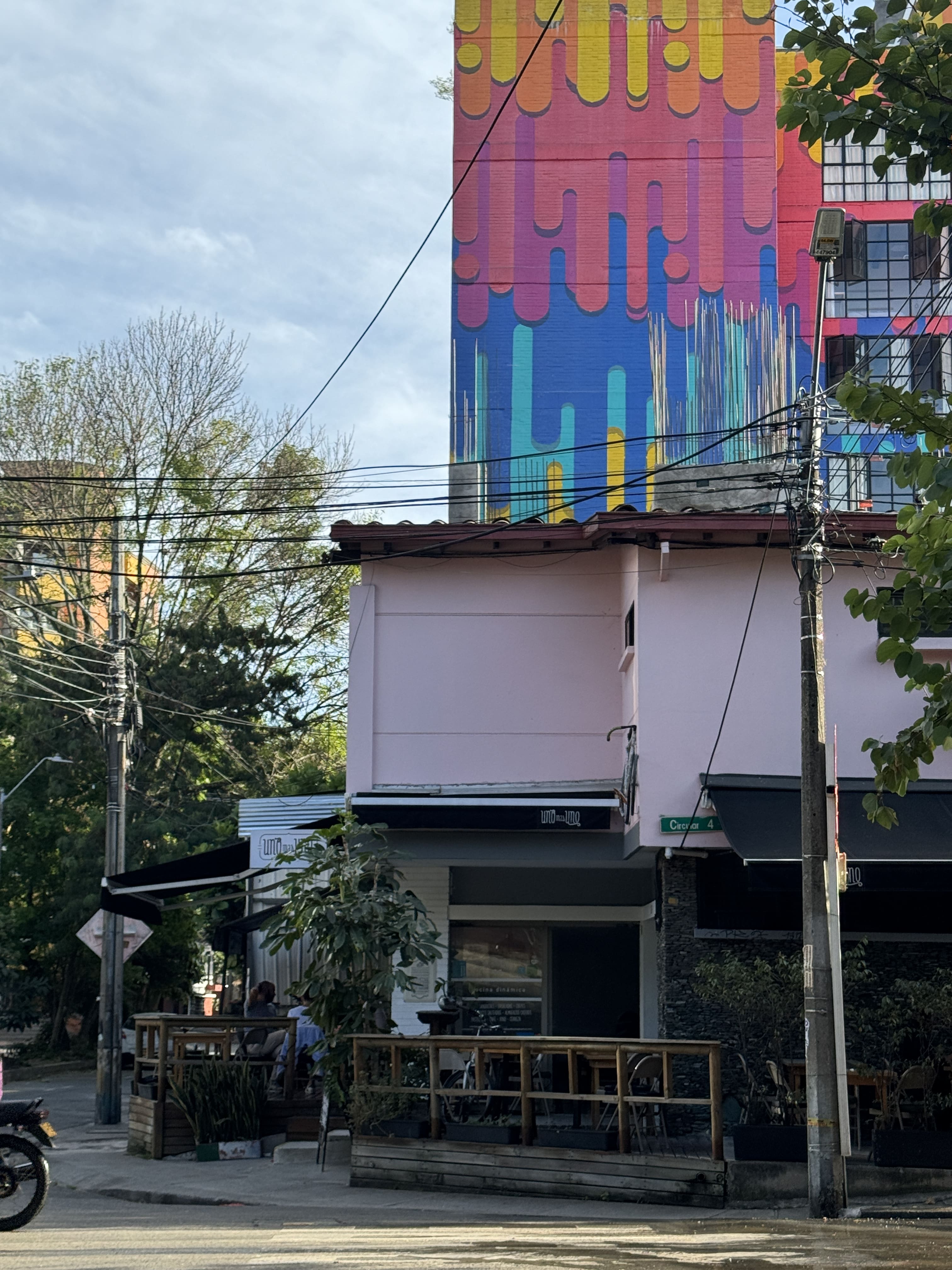 Picture of the street with the restaurant with a colorful wall in the background